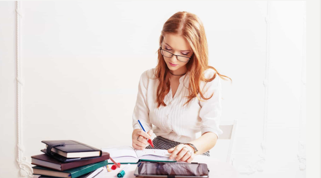 A woman with glasses writing notes representing beginner content writing practice