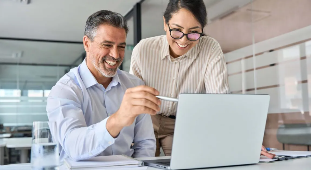 A man and woman collaborating on a laptop learning content writing together