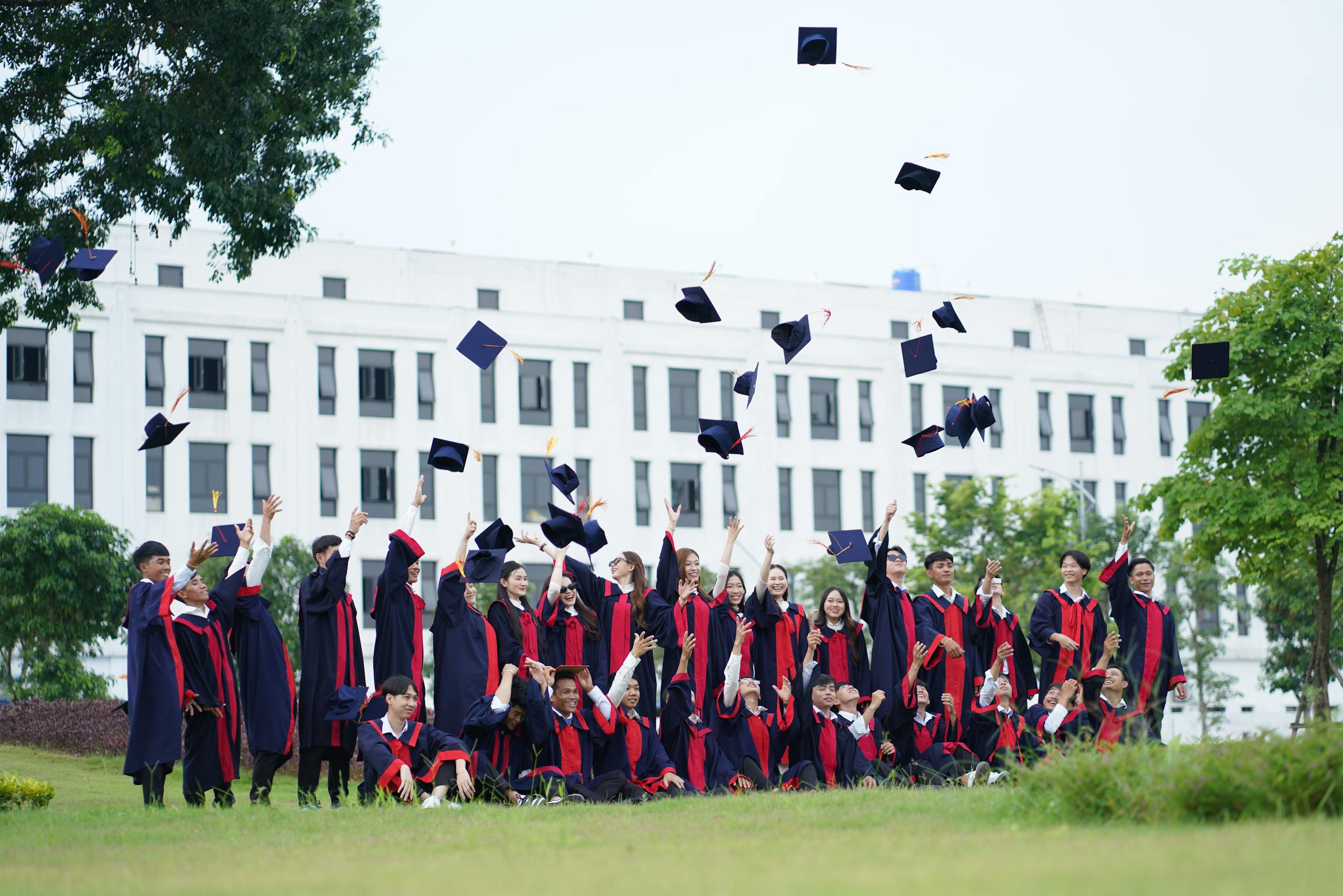 group of graduates celebrating by throwing caps into the air representing overseas education success