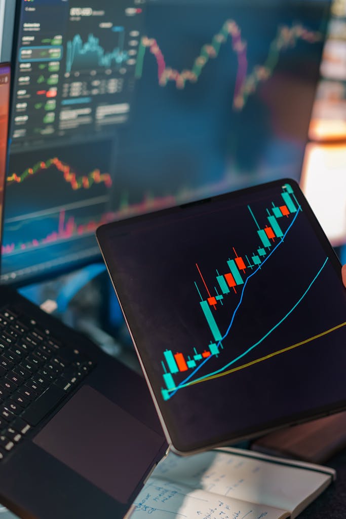 tablet displaying stock market candlestick chart with laptop for online earning and financial analysis Pakistan