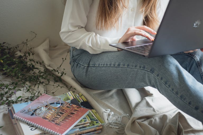 online earning for students in Pakistan woman studying on laptop at home with textbooks