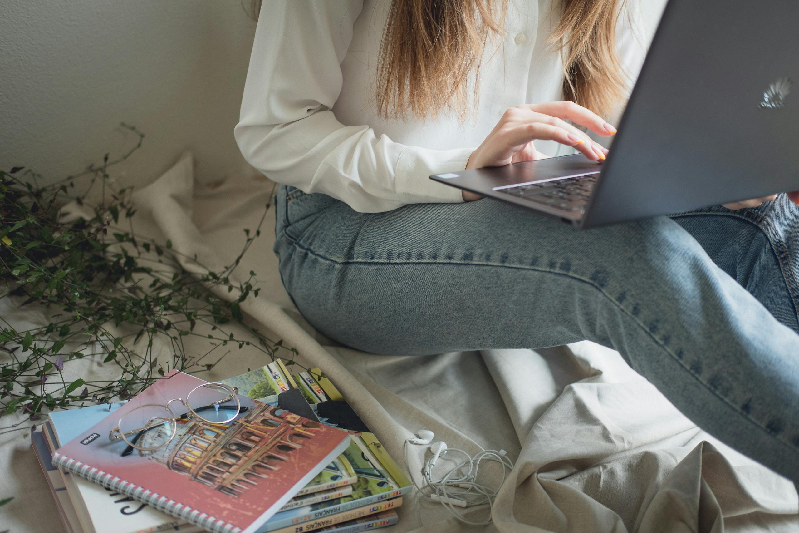online earning for students in Pakistan woman studying on laptop at home with textbooks
