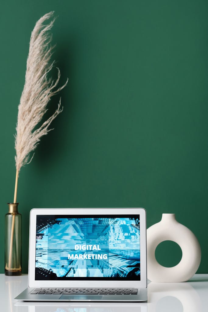 Laptop displaying digital marketing on screen with decorative items on a desk